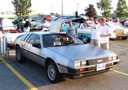Admirers admiring the DeLorean at the show.